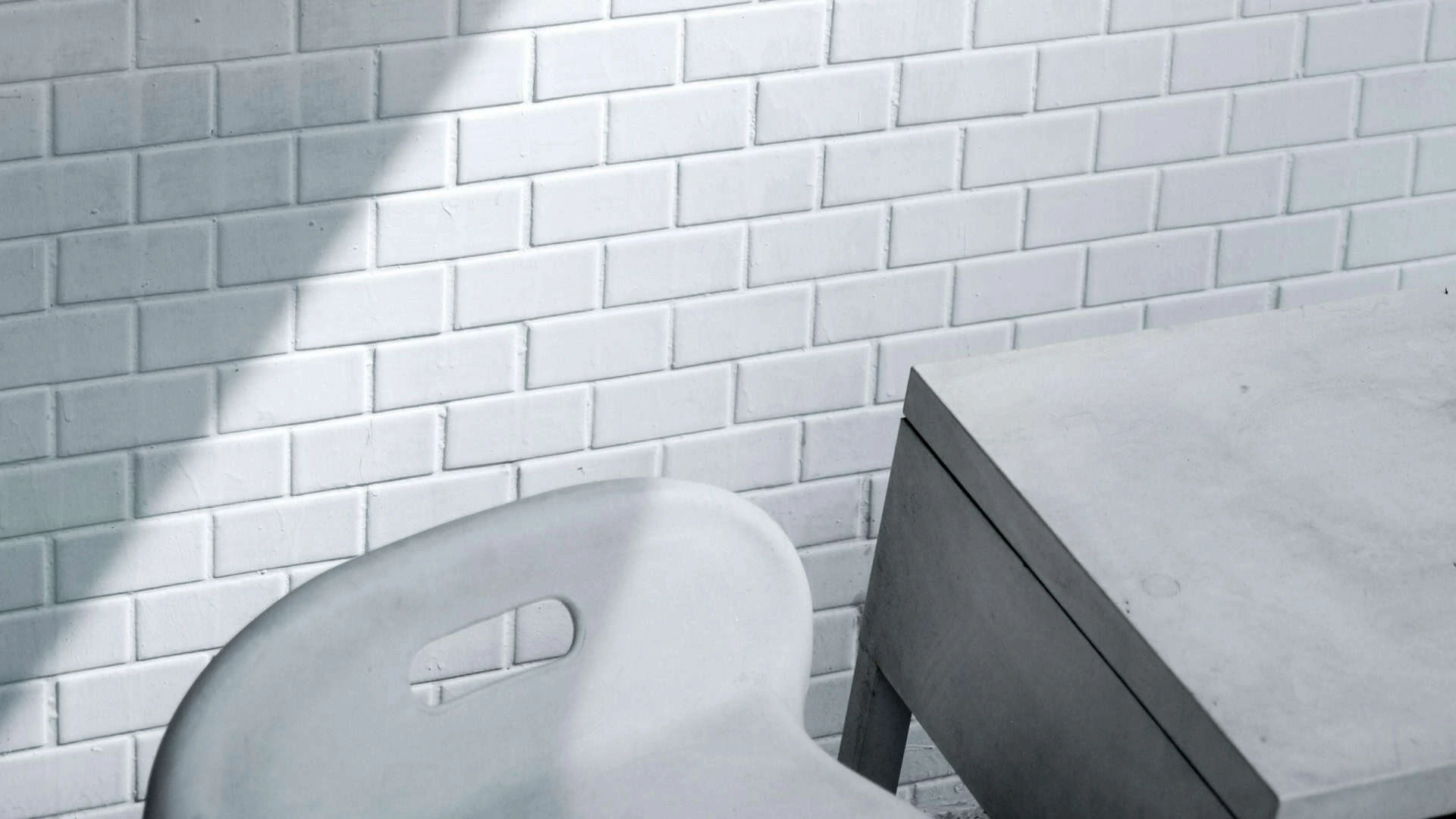 Whitewashed brick wall with white-painted bricks and a chair in the foreground